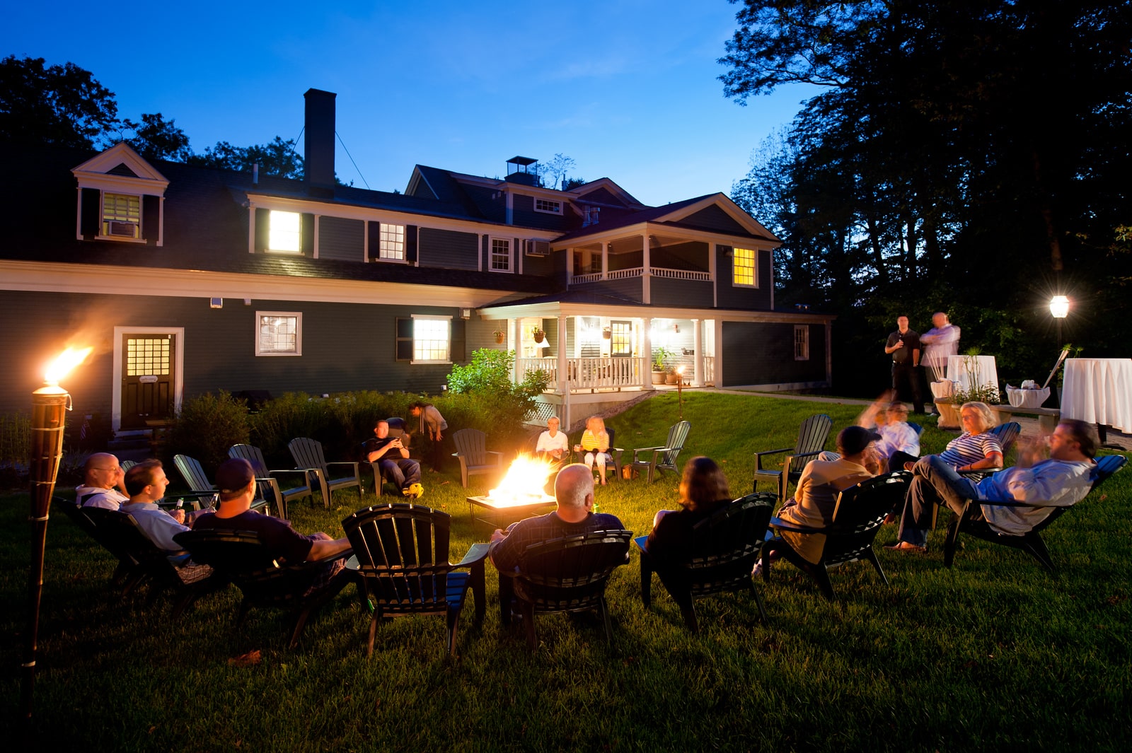 Guests of a hotel by the firepit in the courtyard