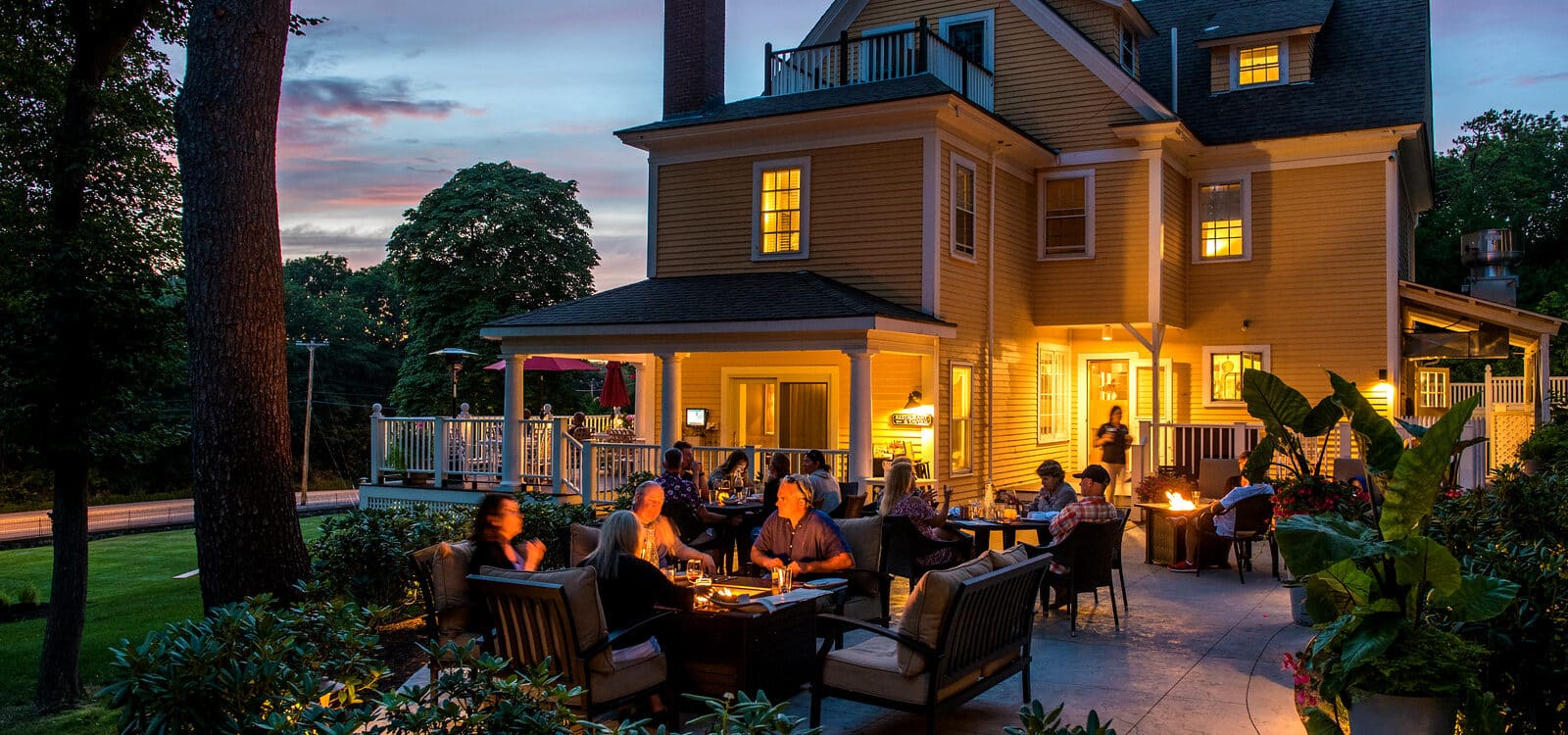 Guests of a hotel by the firepit in the courtyard