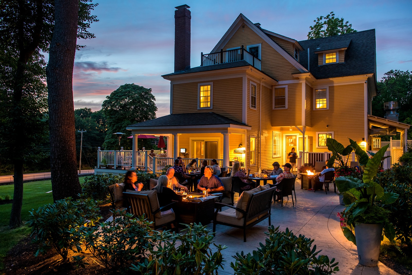 Guests of a hotel by the firepit in the courtyard