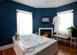 Jacuzzi in room with fireplace and champagne